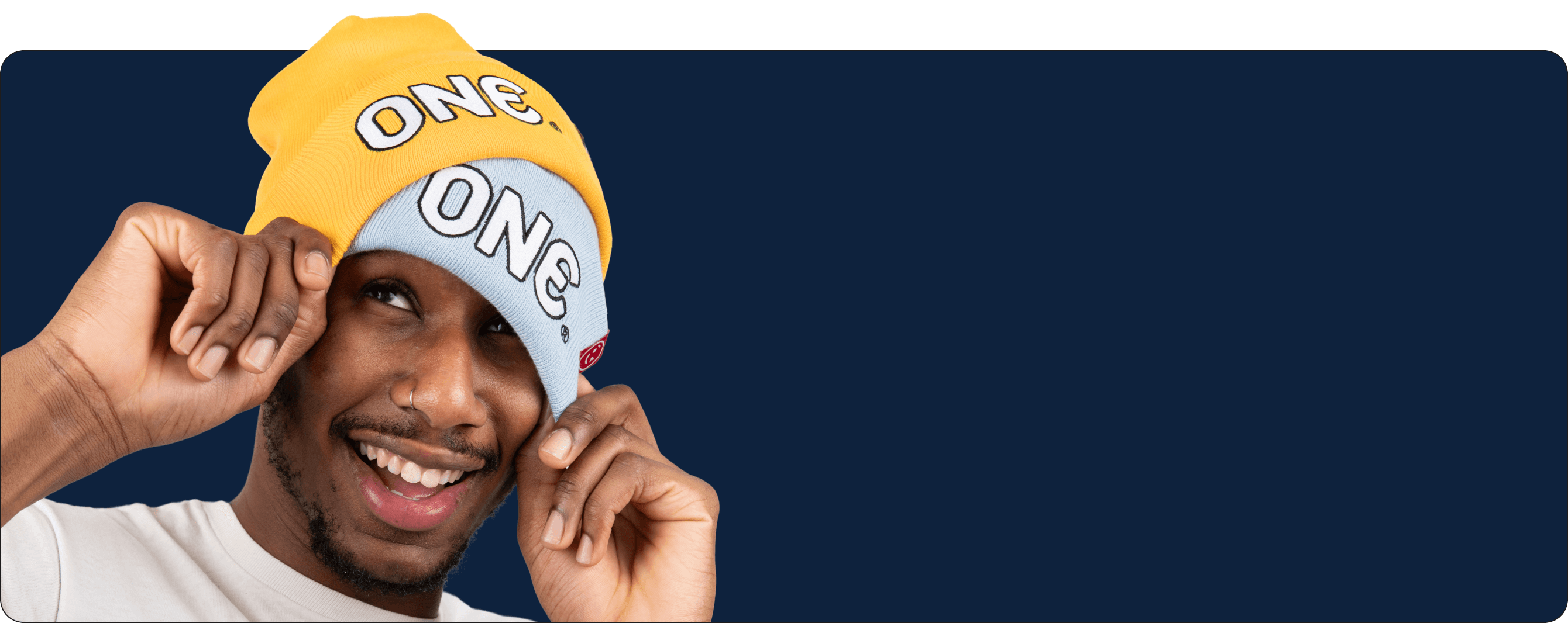 Man wearing a yellow and white beanie with 'ONE' branding on a blue background