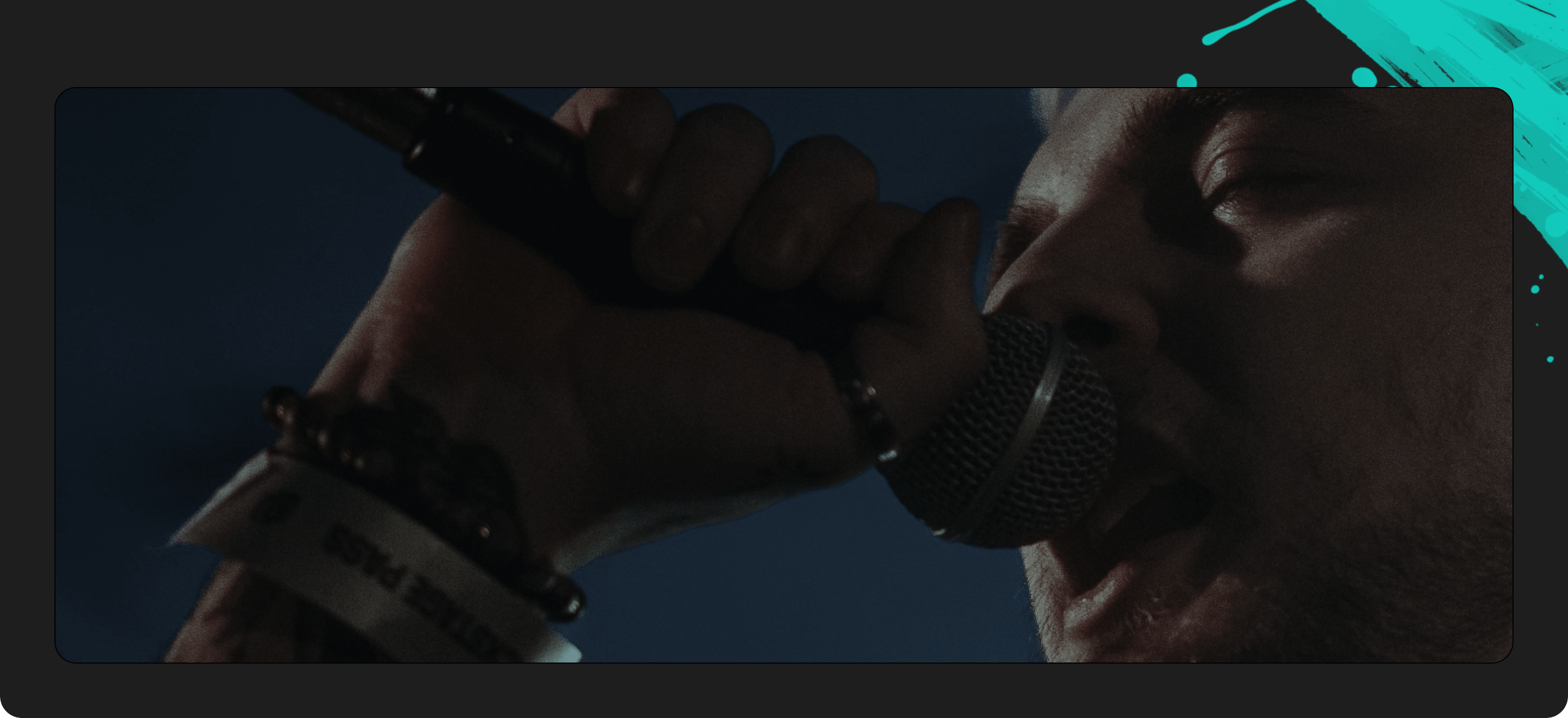 Person singing into a microphone with a dark background