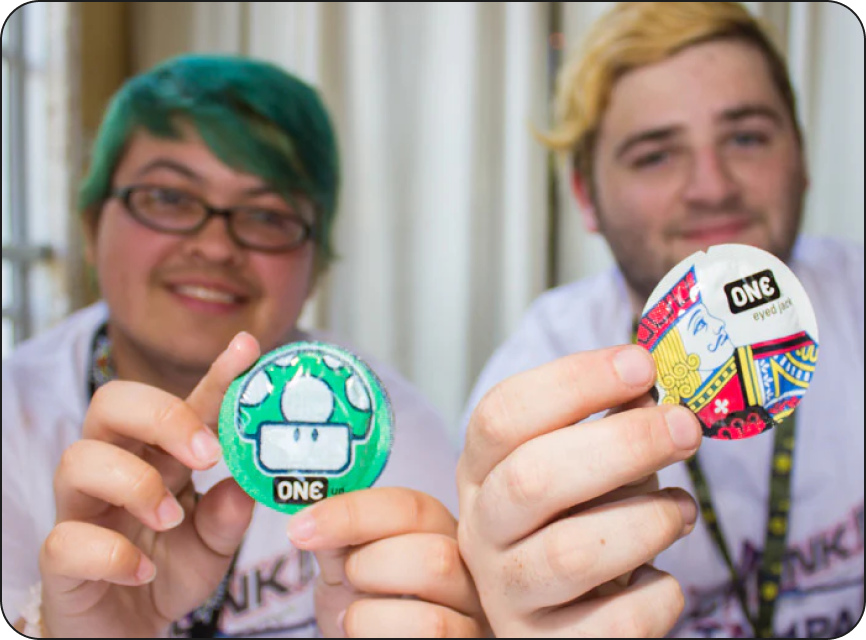 Two people holding colorful buttons with 'ONE' branding.