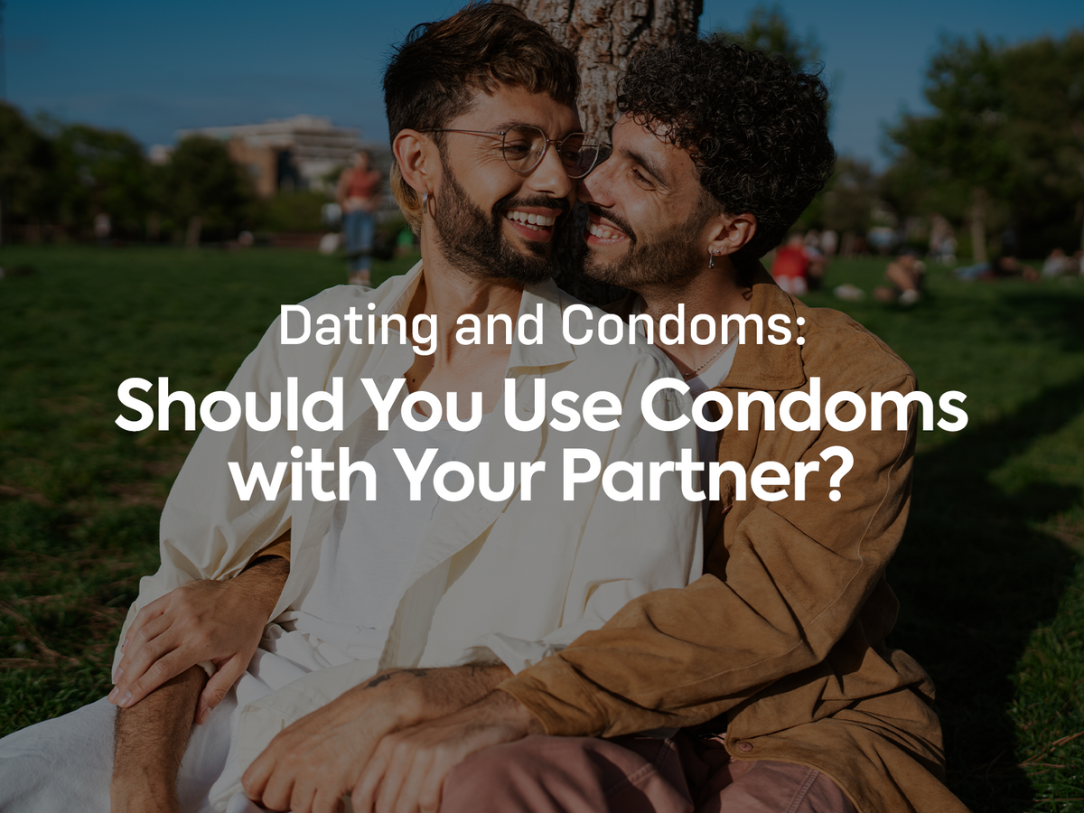 Blog Cover Image. Happy couple sitting outside with text: Dating and Condoms: Should You Use Condoms with Your Partner?