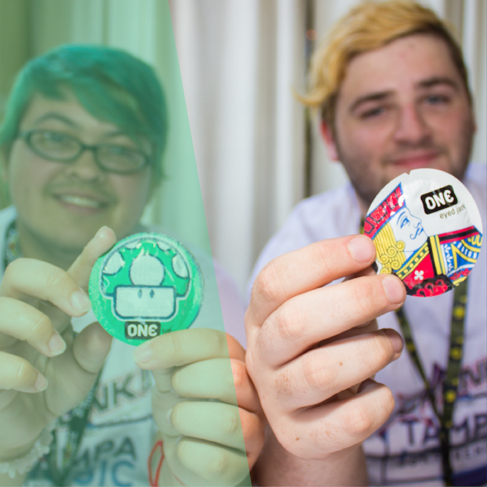 Two people smiling and holding up their favorite ONE Condoms!