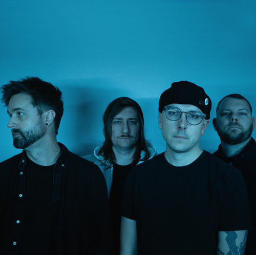 Image of Braeburn Records - a ONE on Stage band. Four people dress in black standing against a blue background. 