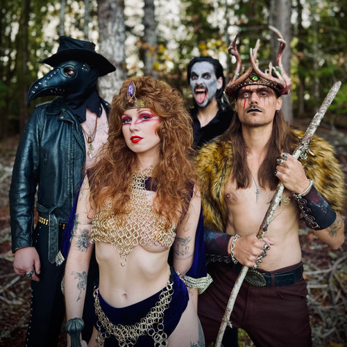 Image of Castle Rat - a new ONE on Stage band. Image shows four band members standing i the forest. Each person is dressed in costume with head pieces and face paint.