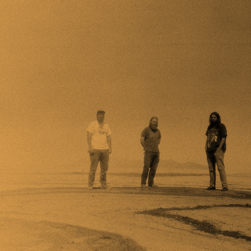 Image of Chrome Ghost - a new ONE on Stage band. Three people standing on beach.