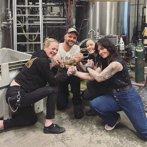 Image shows Empress Rising - a new ONE On Stage band. Four people kneel holding hands with machinery behind them.