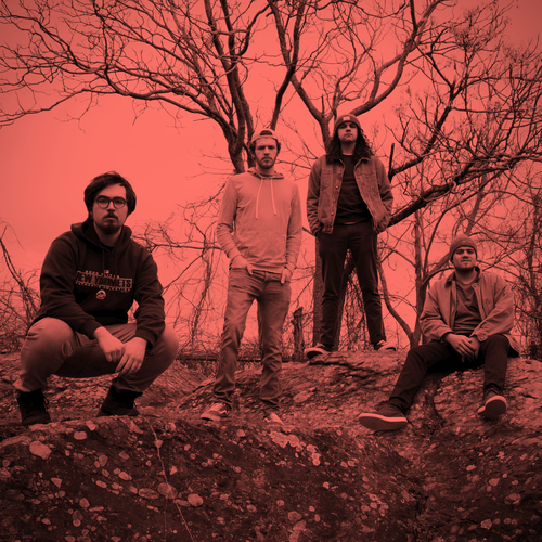 Image of Fossil - a ONE on Stage band. Four people standing and crouching in woods. B&W images with red hue. 