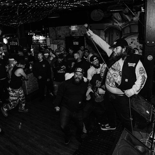 Black and white photo of a crowd at a concert with a performer on stage.