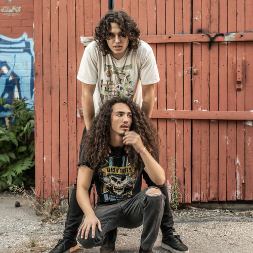 Image of Homestyle Diner Rolls - a ONE on Stage Band. One person and another person crouching. Shed in background. 