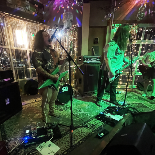 Image of Ritual Caster - a ONE on Stage band. Two people on stage playing guitar and singng.