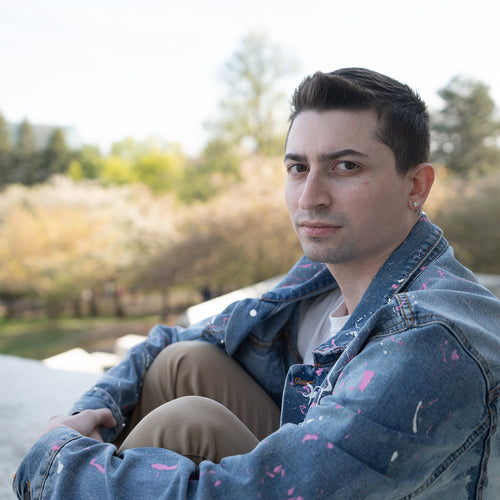 Man sitting outdoors with a blurred natural background