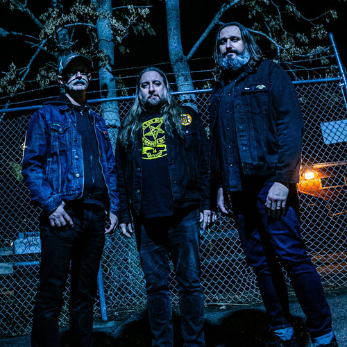 Image of Worshipper - a ONE on Stage band. Three people standing in front a chain fence.