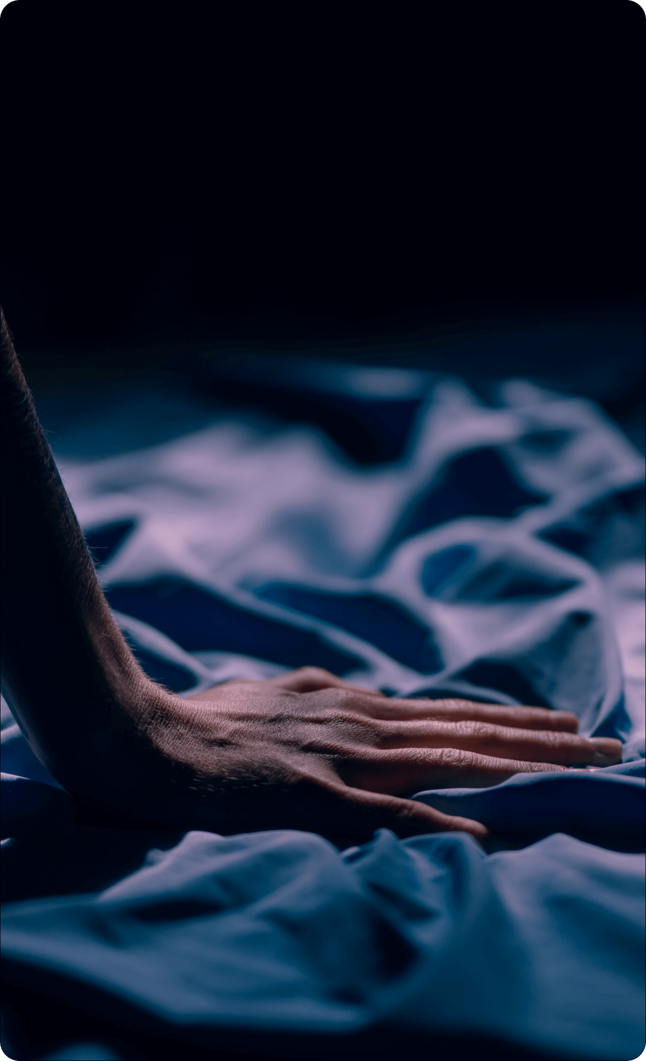 Hand resting on a textured fabric surface with a dark background