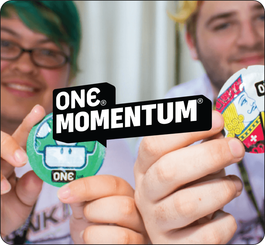 Two people holding colorful stickers with 'ONE MOMENTUM' logo in the foreground.